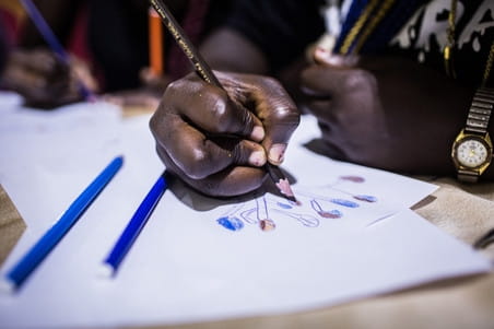 Terugkeerders tekenen tijdens een IOM-training voor bedrijfsvaardigheden in Lagos, Nigeria, op 16 oktober 2018. Foto: Tom Saater (voor De Correspondent)