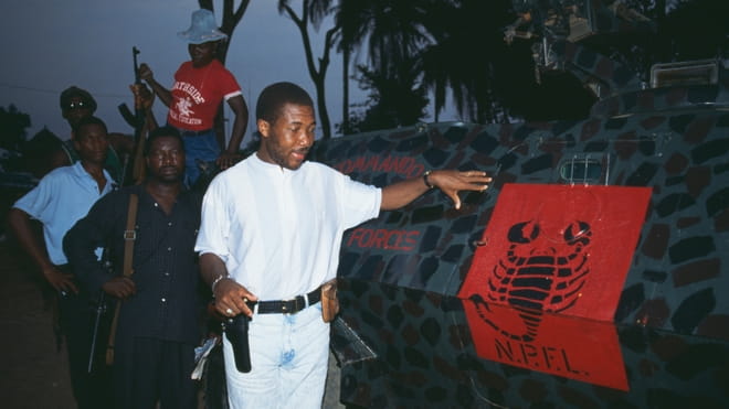 Charles Taylor naast een trainingskamp van rebellengroep National Patriotic Front of Liberia, waarvan hij de leider was. Foto: Patrick Robert / Getty