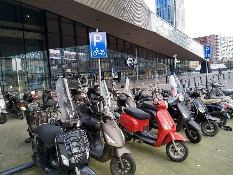 Scooteraars mogen gratis parkeren op 25 stappen van de ingang van Rotterdam Centraal, aan het fietspad en het fietstunneltje. Fietsers niet. Foto Thalia Verkade