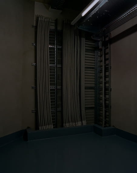De kelder van SafeHost, een particulier datacentrum, gebouwd in 2000 in een voorstad van Genève. Onder hun klanten bevinden zich zowel financiële instanties en internationale organisaties als particuliere bedrijven. Het complex beslaat een oppervlak van 10.000 m2. Uit de serie ‘Deposit’ door Yann Mingard.
