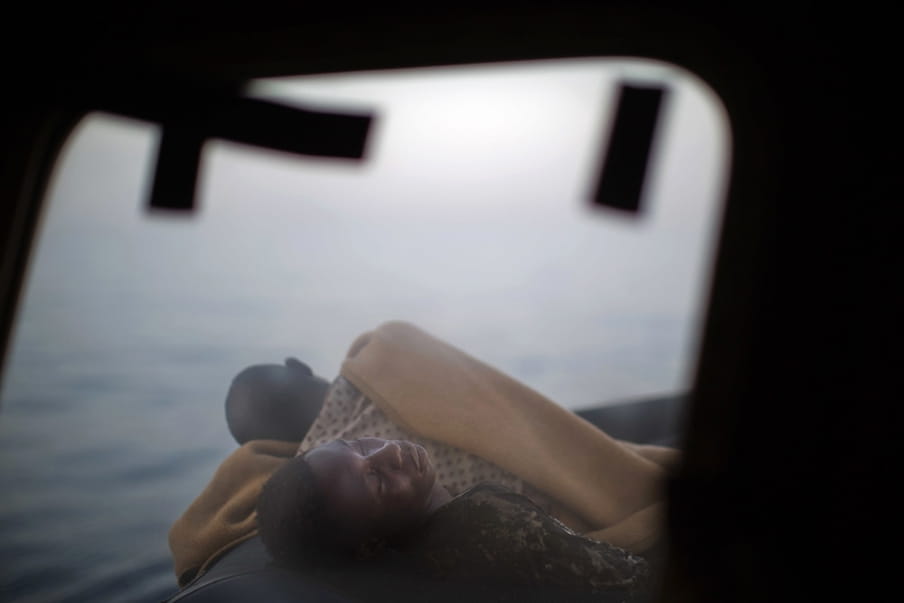 Migranten slapen op het dek van de Golfo Azzurro terwijl dit reddingsschip de haven van Pozallo binnenvaart. Er zijn honderden migranten aan boord die zijn gered door leden van Open Arms op 17 juni, 2017. Foto: Emilio Morenatti / AP