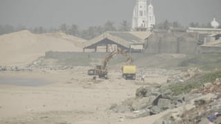 Aan de kust van Tamil Nadu, waar het landschap flink is aangetast door zandafgravingen. Op de achtergrond zie je een rij bananenbomen die lijden onder deze werkzaamheden.