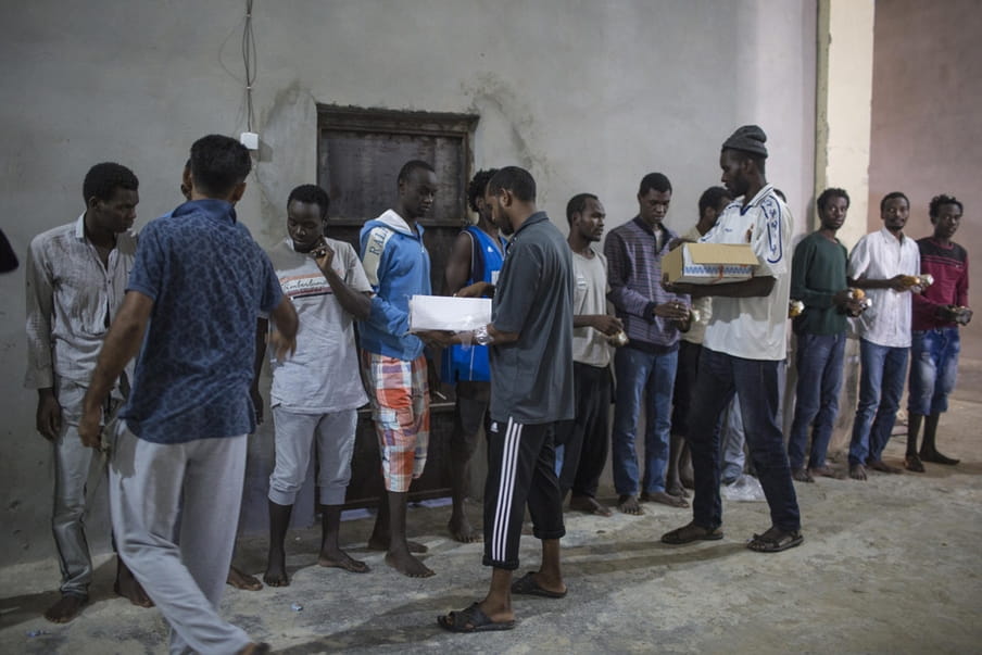 Illegale migranten ontvangen een maaltijd in een detentiecentrum in Zawiya, Libië, 28 september, 2016. Foto: Asmaa Waguih / Polaris