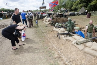 Vrouw maakt een foto van een jongetje die oorlog naspeelt