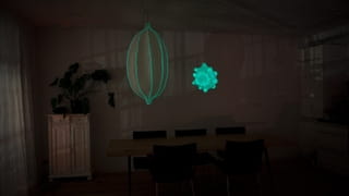 Foto van een woonkamer bij nacht. Boven de eettafel hangen twee glow in the dark lampen.