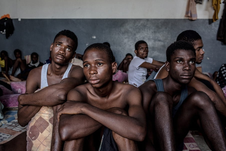 De zestienjarige Precious (midden) en andere migranten zitten in het Abu Salim-detentiecentrum in Tripoli, Libië. Foto: Daniel Etter / Redux