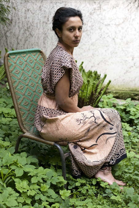 Charisma Pical in een jurk van oma en planten in de Hortus Botanicus. Foto: Amber Toorop (voor De Correspondent)