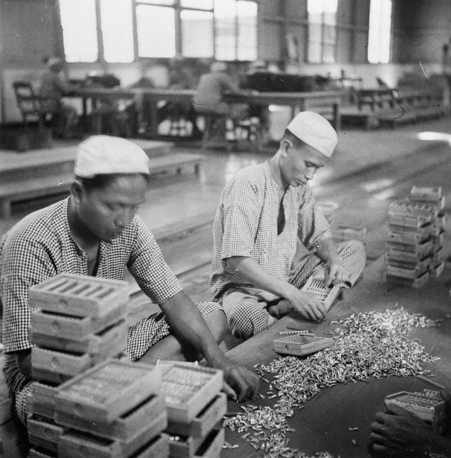 In de opiumfabriek te Batavia worden de tubes in houten doosje verpakt, Java, 1936. Foto: Foto: Collectie Nationaal Museum van Wereldculturen. Coll.nr. TM-10012174