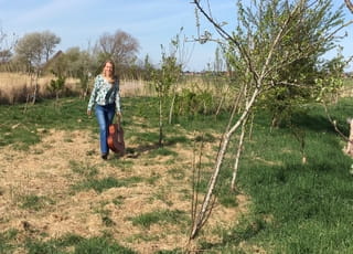 Saskia met haar gitaar in het veld.