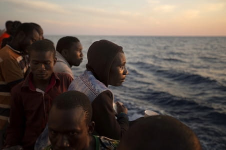 Migranten zijn aan boord van de Golfo Azzurro terwijl dit reddingsschip de haven van Pozallo binnenvaart. Er zijn honderden migranten aan boord die zijn gered door leden van Proactiva Open Arms op 17 juni, 2017. Foto: Emilio Morenatti / AP