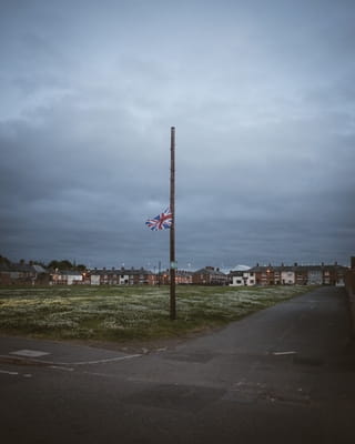 Een vlaggenmast met een Britse vlag op halfstok voor een wijk in Belfast.